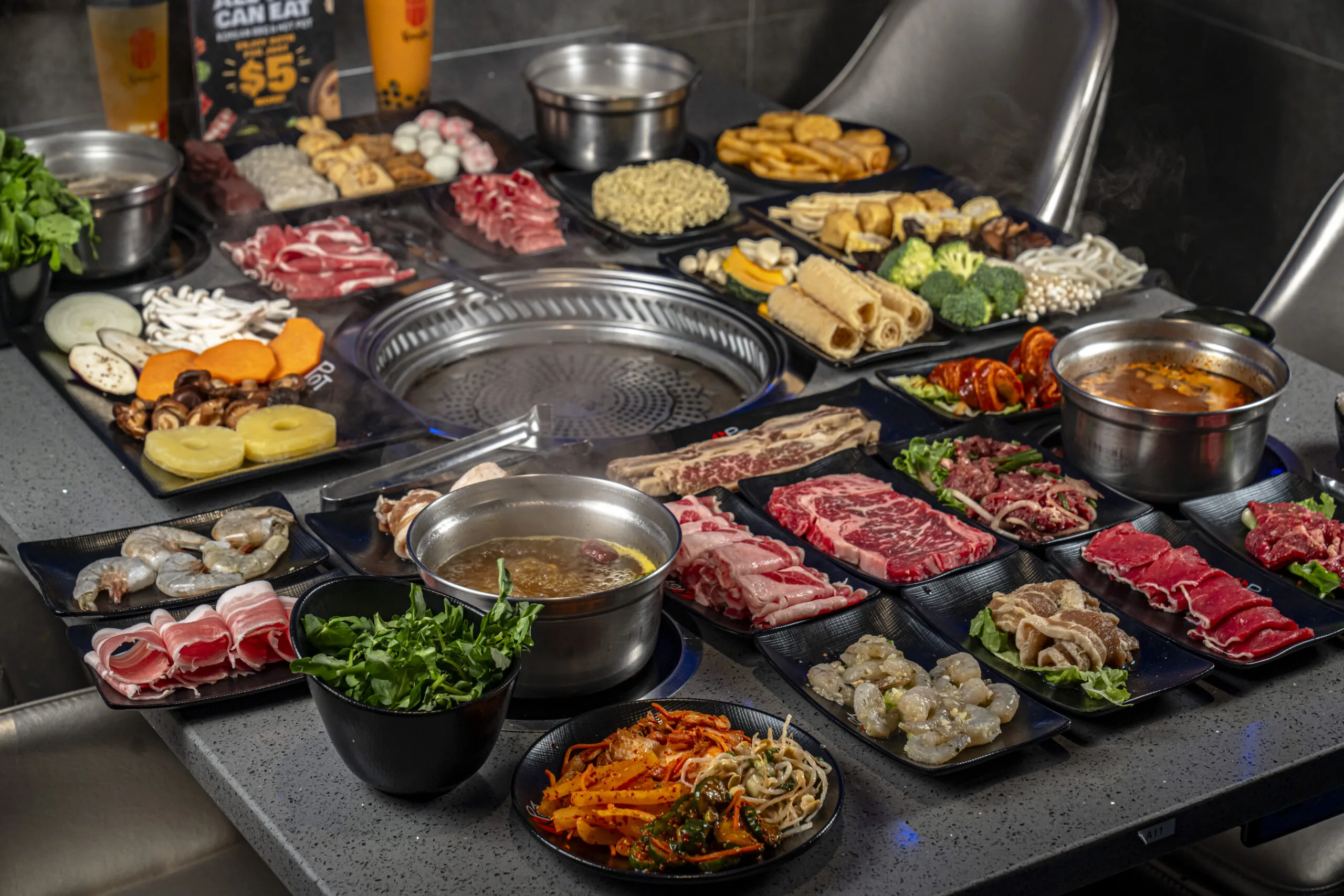 Table at KPOT with Hot Pot and meats ready for grilling