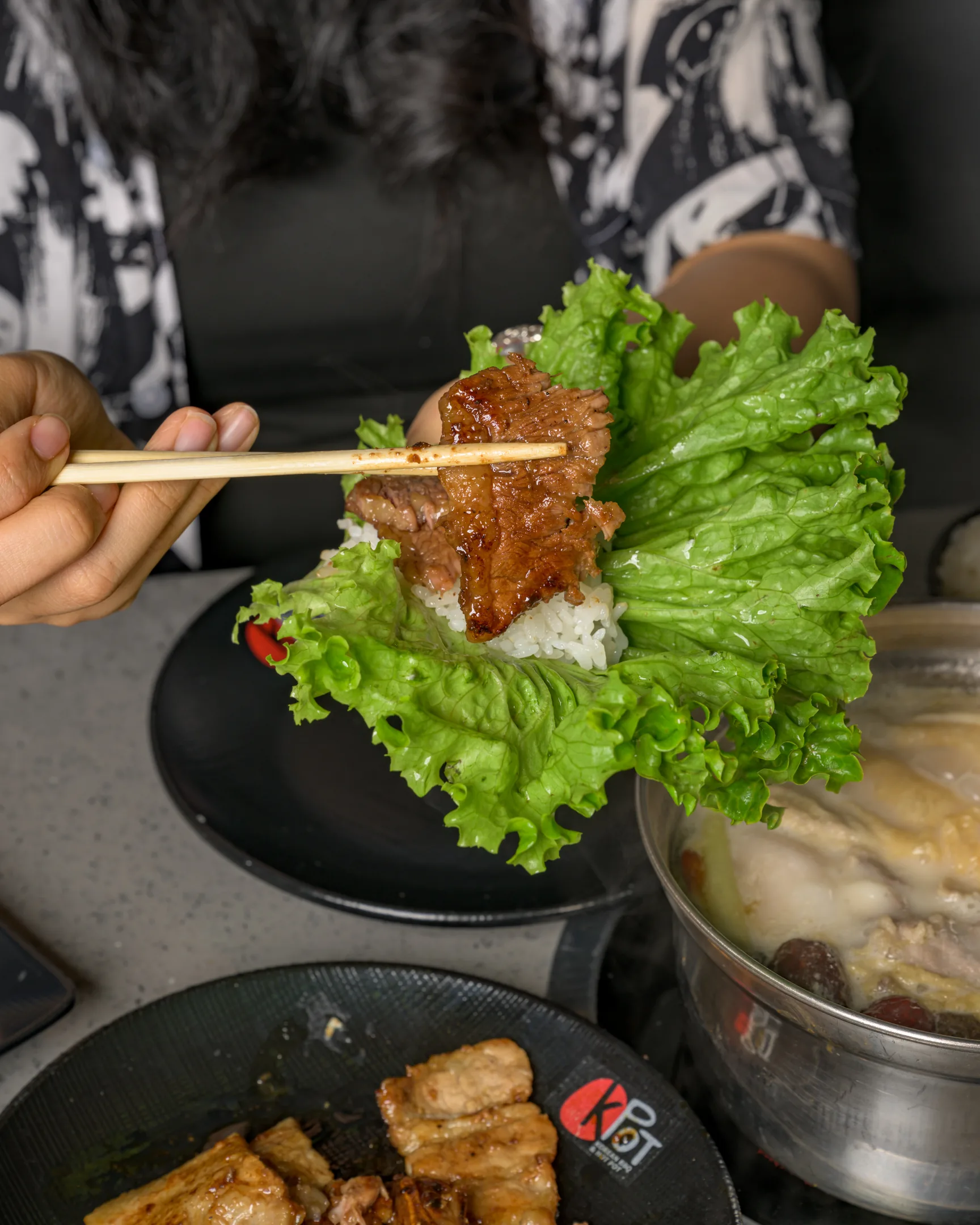 Person using cooked steak to make a lettuce wrap at KPOT