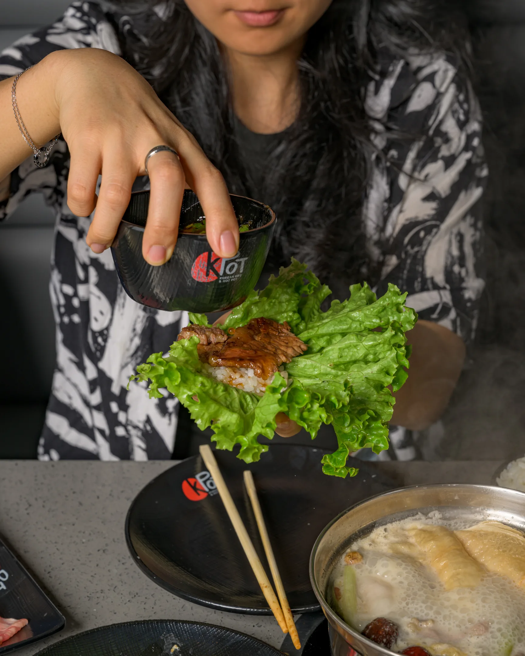 Grilled beef on a bed of rice and lettuce with sauce drizzled